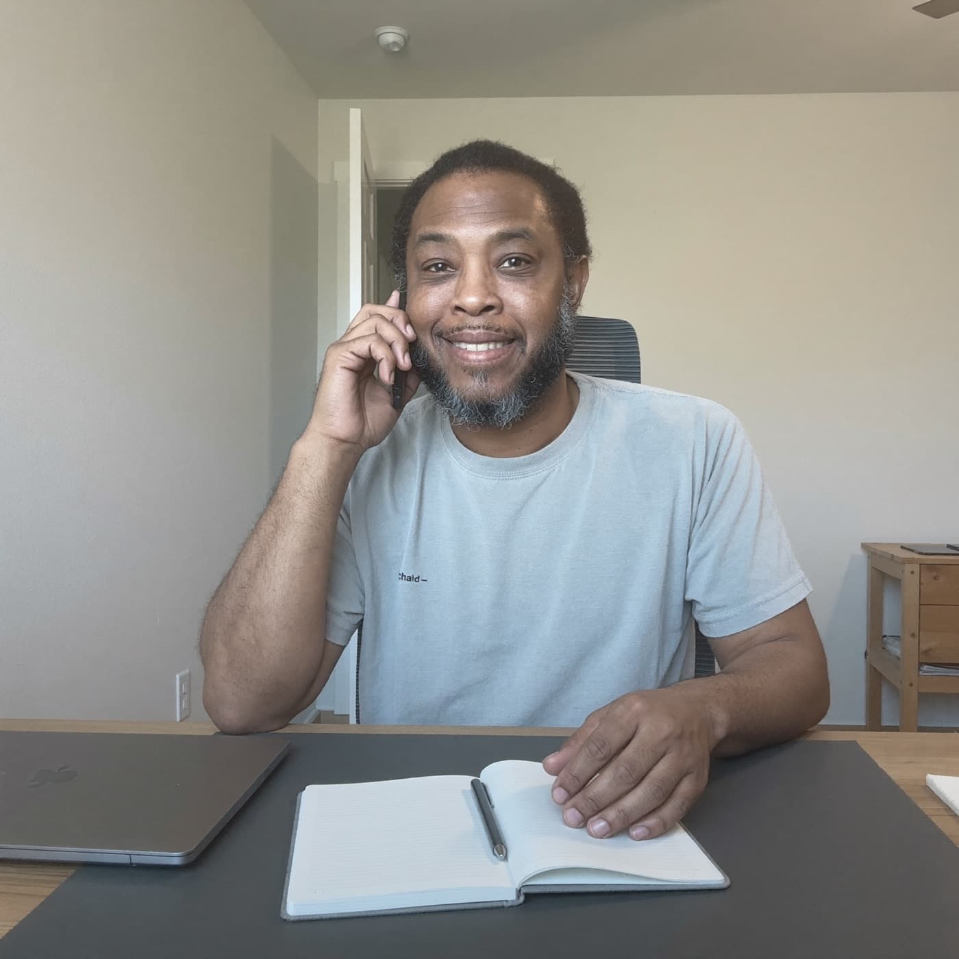 Chad on a phone call at his desk, taking notes